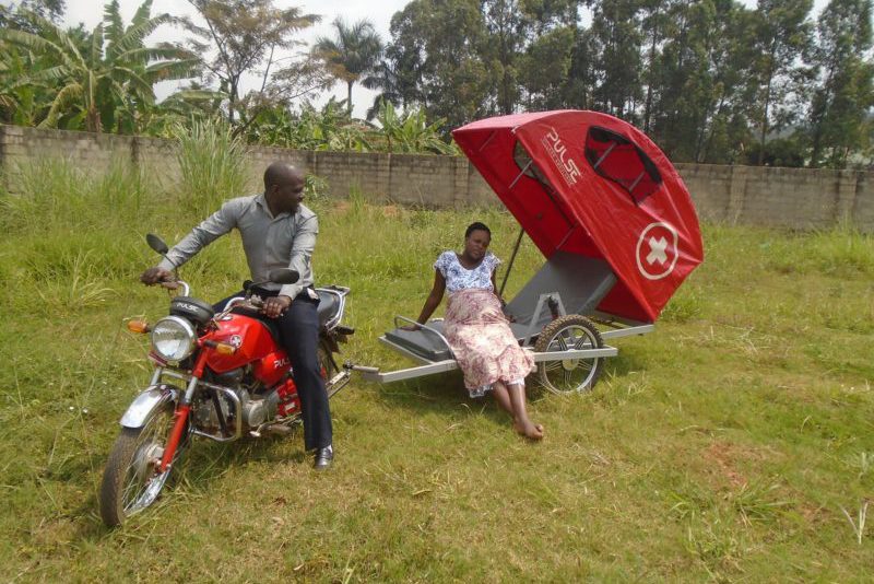Pregnant mother sitting in motorcycle ambulance trailer